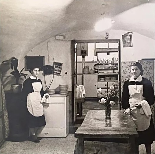 La cucina del ristorante negli anni Cinquanta, con due cameriere in grembiule