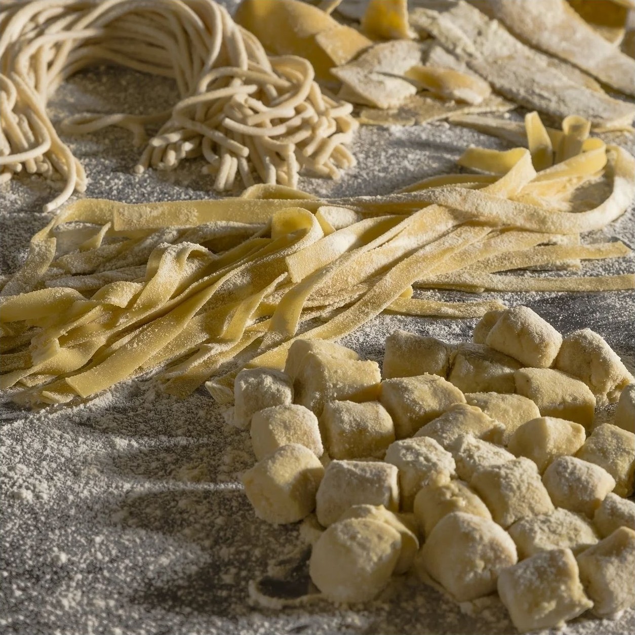 Tagliatelle, pici e gnocchi appena fatti, infarinati sul banco di lavoro