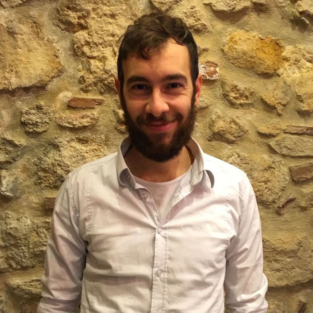 Antonio Senes sorride davanti al muro in pietra della sala