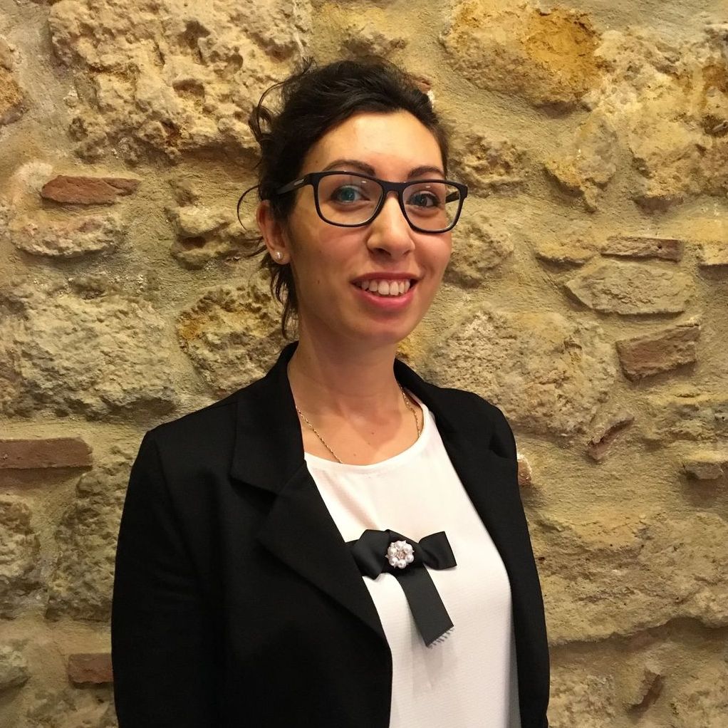 Sara Senes sorride davanti al muro in pietra della sala